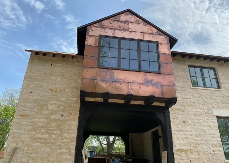 Copper metal panel facade on a stone building for Roof Repair in Lochbuie